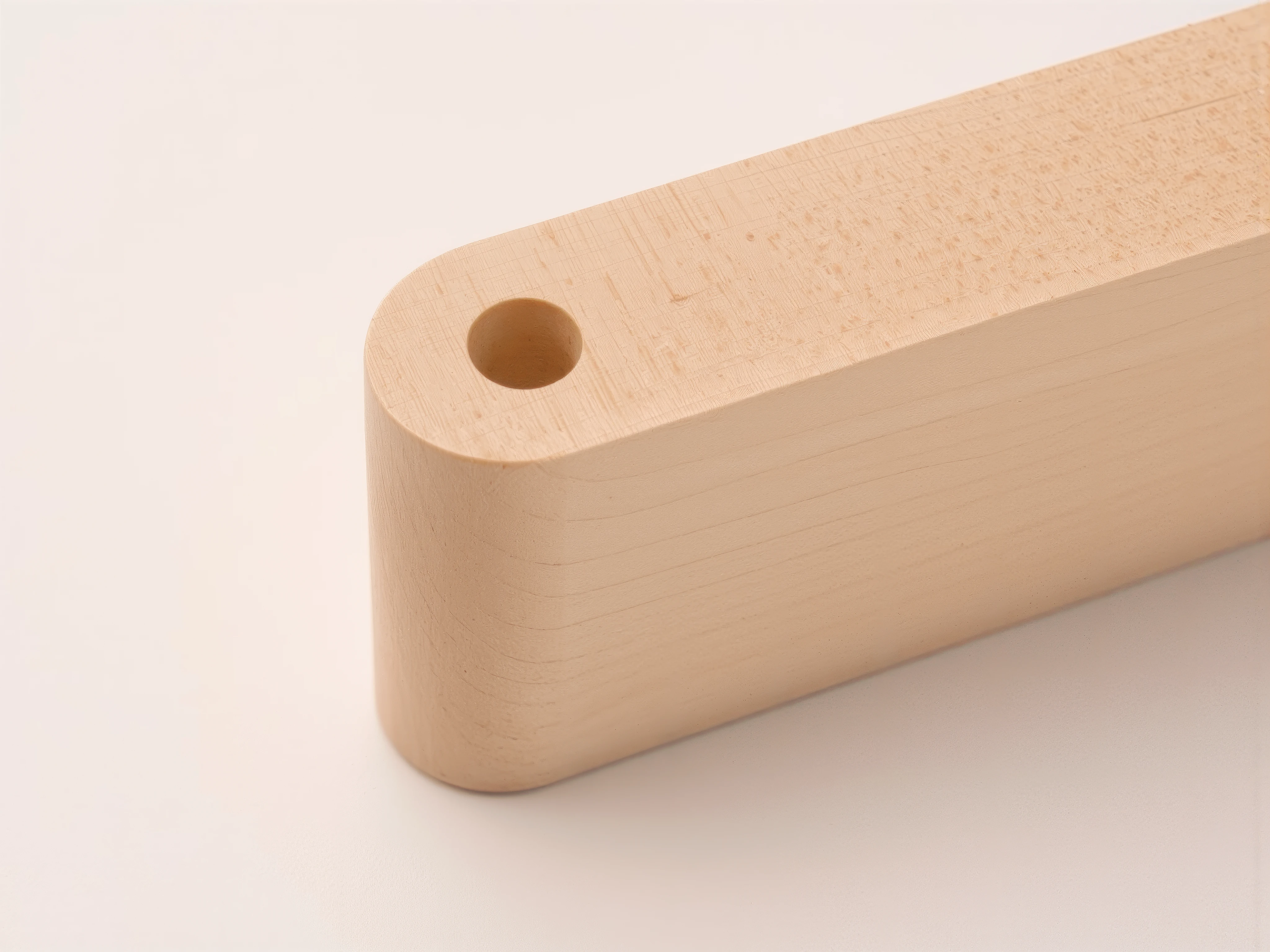 Close-up of a light maple MUUJEE desk organizer, showing the rounded corner and pen slot.
