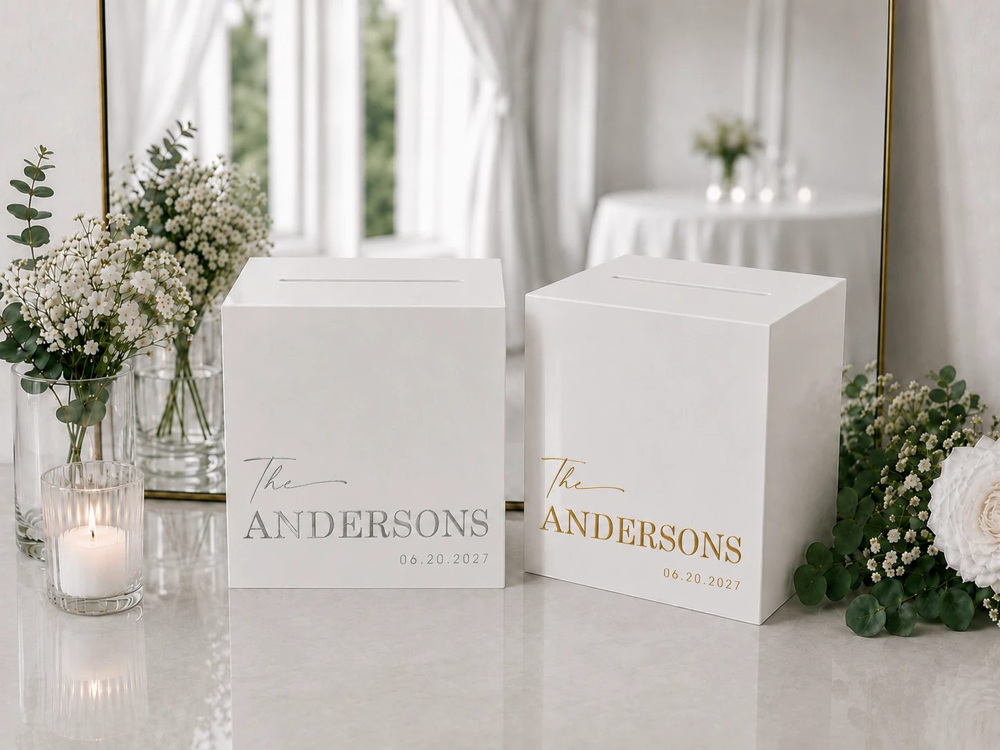Two personalized MUUJEE card boxes reading 'The Andersons,' one in silver foil and one in gold, styled with flowers and a mirror.